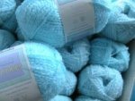 balls of bright light blue wool with a crinkle in it